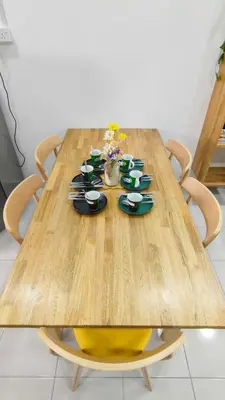 a wooden table with bowls and plates on it at Hygge Living Kampar III Near UTAR in Kampar