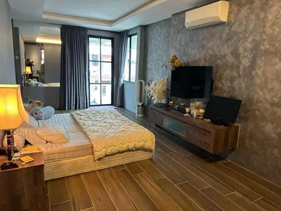 a bedroom with a large bed and a flat screen tv at The Eve Homestay in Tanjung Bungah