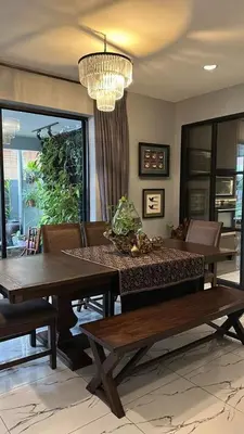a dining room with two tables and a chandelier at The Eve Homestay in Tanjung Bungah