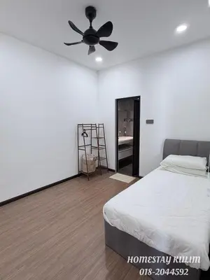 a bedroom with a bed and a ceiling fan at Stylish Landed Stay in Kulim