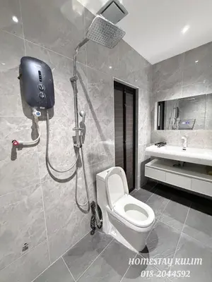 a bathroom with a shower with a toilet and a sink at Stylish Landed Stay in Kulim