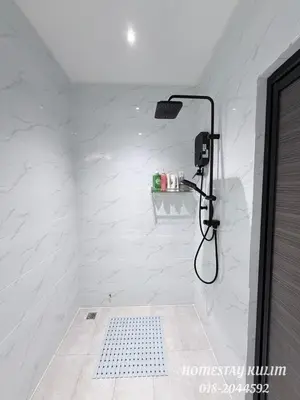 a bathroom with a shower with white marble walls at Stylish Landed Stay in Kulim