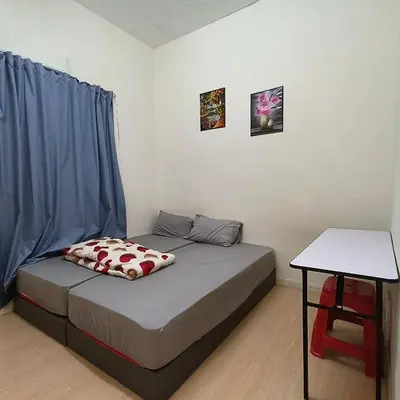 a small bedroom with a bed and a table at POLI Homes in George Town