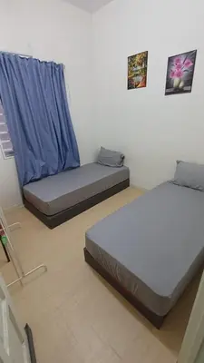 a bedroom with two beds and a blue curtain at POLI Homes in George Town