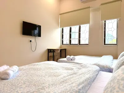 two beds in a room with a tv on the wall at Kamar Kita Mūslim-friendly at 11 Victoria in George Town