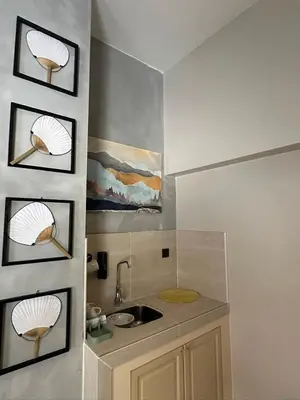 a kitchen with a sink and some pictures on the wall at Morikoi Cottage in Ipoh