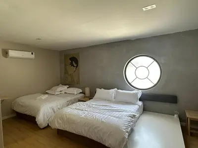two beds in a room with a window at Morikoi Cottage in Ipoh
