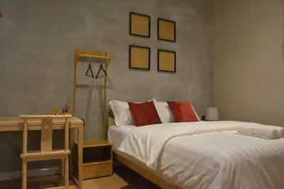 a bedroom with two beds and a nightstand with a bed sidx sidx at Morikoi Cottage in Ipoh