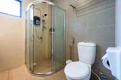 a bathroom with a toilet and a glass shower at 32 cozy stay Projector, Karaoke , BBQ, 7 carpark in Ipoh