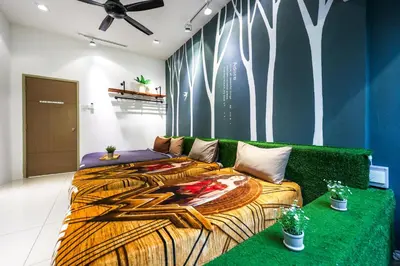 a room with two beds and a green couch at 32 cozy stay Projector, Karaoke , BBQ, 7 carpark in Ipoh