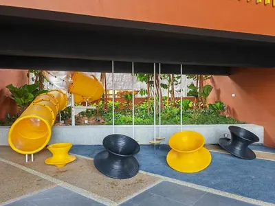 a playground with a yellow slide and yellow chairs at IPOH Piccadilly Cozy unit with City View in Ipoh