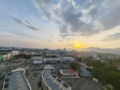 a view of a city with the sunset in the background at IPOH Piccadilly Cozy unit with City View in Ipoh