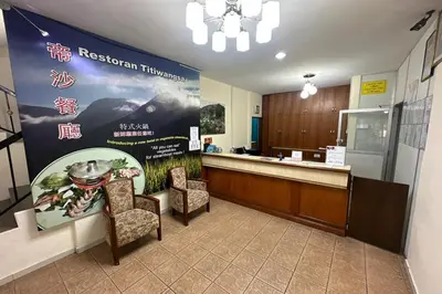 a reception area of a restaurant with chairs and a sign at Hotel Titiwangsa in Gua Sai