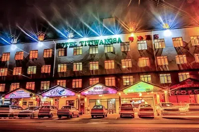 a building with cars parked in front of it at night at Hotel Titiwangsa in Gua Sai