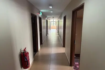 a corridor of a hallway with a red fire extinguisher at Hotel Titiwangsa in Gua Sai