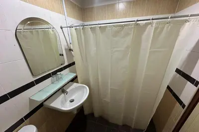 a bathroom with a shower curtain and a sink at Hotel Titiwangsa in Gua Sai
