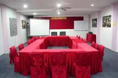a conference room with a red table and chairs at Hotel Titiwangsa in Gua Sai