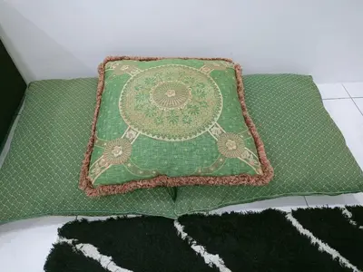 a green pillow sitting on top of a bed at Kota Emas Homestay -in Sarang Semut, Kedah in Gua Sai