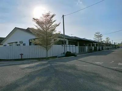 a white building with a white fence next to a street at Kota Emas Homestay -in Sarang Semut, Kedah in Gua Sai