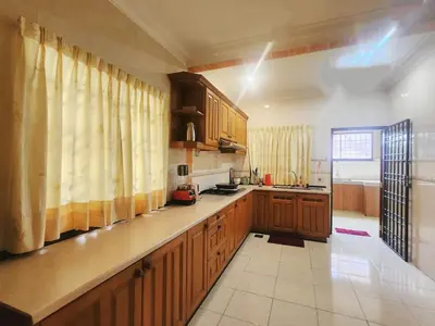 a kitchen with wooden cabinets and a counter top at Ipoh sunway lostworld 5br 15pax in Tambun