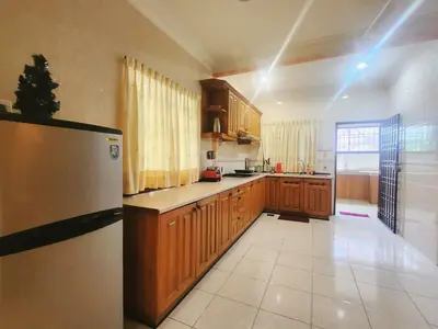 a kitchen with wooden cabinets and a refrigerator at Ipoh sunway lostworld 5br 15pax in Tambun