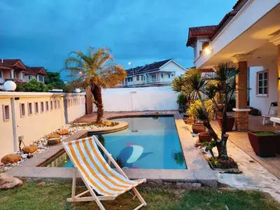 a yard with a swimming pool and two lawn chairs at IPOH PRIVATE POOL VILLA 6BR 23pax in Ipoh