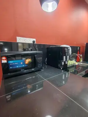 a microwave sitting on a counter in a kitchen at Cozy Corner Homestay Bandar Utama Gua Musang in Gua Musang