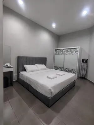 a bedroom with a large bed with white sheets at Cozy Corner Homestay Bandar Utama Gua Musang in Gua Musang