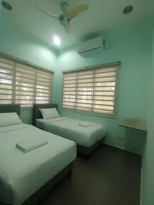 a room with two beds and two windows at Cozy Corner Homestay Bandar Utama Gua Musang in Gua Musang