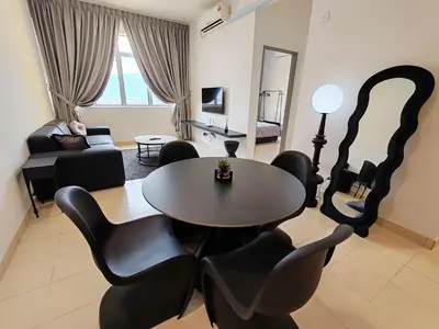 a living room with a table and black chairs at BW Urban Stay in Ipoh