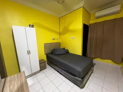 a bedroom with a bed and a yellow wall at Teratak Minda Cerdas in Kulim