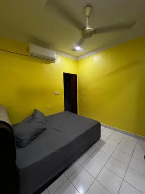 a bed in a room with a yellow wall at Teratak Minda Cerdas in Kulim
