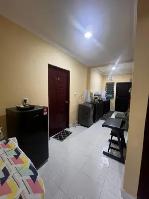 a living room with a refrigerator and a kitchen at Teratak Minda Cerdas in Kulim