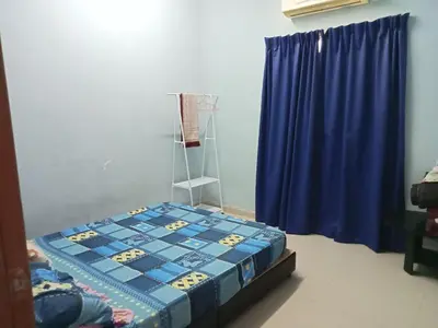 a bedroom with a bed and a blue curtain at HaniHomestay4U in Kuala Lipis