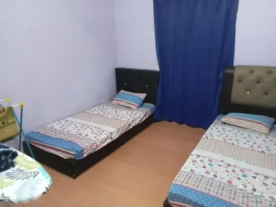 two beds in a room with blue curtains at HaniHomestay4U in Kuala Lipis