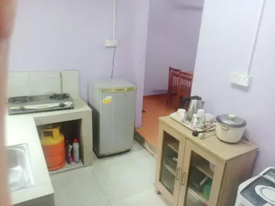 a small kitchen with a refrigerator and a table at HaniHomestay4U in Kuala Lipis