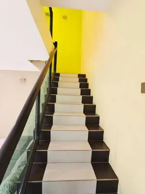 a staircase in a building with a yellow wall at ipoh botani 4br12pax pets friendly muji luxe in Ipoh