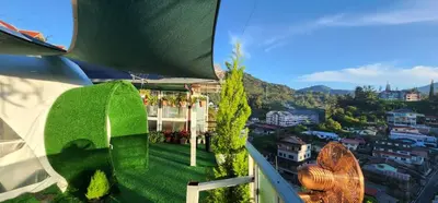 a view from the balcony of a building with green grass at Mountain View Sameer Glamping in Cameron Highlands