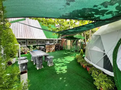 a patio with a table and benches in a yard at Mountain View Sameer Glamping in Cameron Highlands