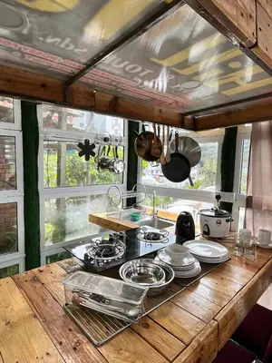 a kitchen with a wooden counter top with plates and pans at Mountain View Sameer Glamping in Cameron Highlands