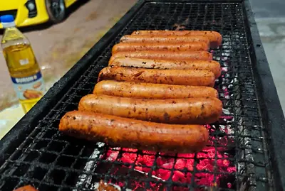 a group of hot dogs cooking on a grill at White House Villa in Sekincan