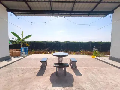 a picnic table and two benches on a patio at White House Villa in Sekincan