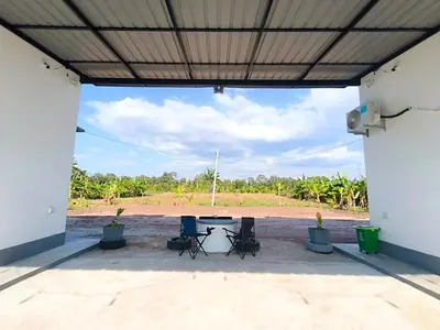 a patio with a table and chairs under a roof at White House Villa in Sekincan