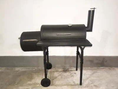 a black grill sitting on top of a stool at White House Villa in Sekincan