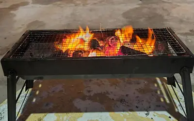 a grill with a bunch of fire in it at White House Villa in Sekincan