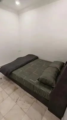 a bed sitting in a room next to a wall at DouDou's House in Simpang Ampat