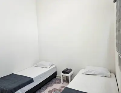 a bedroom with two beds and a small table at Teluk Intan Bajet Homestay Landed 3Bedrooms in Teluk Intan