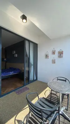 a table and chairs in a room with a bedroom at The Landmark By Pearl Heritage Homestay & Guest House in Tanjong Tokong