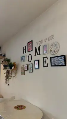 a room with a white wall with pictures on the wall at The Landmark By Pearl Heritage Homestay & Guest House in Tanjong Tokong