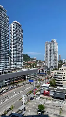 a city with tall buildings and a parking lot with cars at The Landmark By Pearl Heritage Homestay & Guest House in Tanjong Tokong
